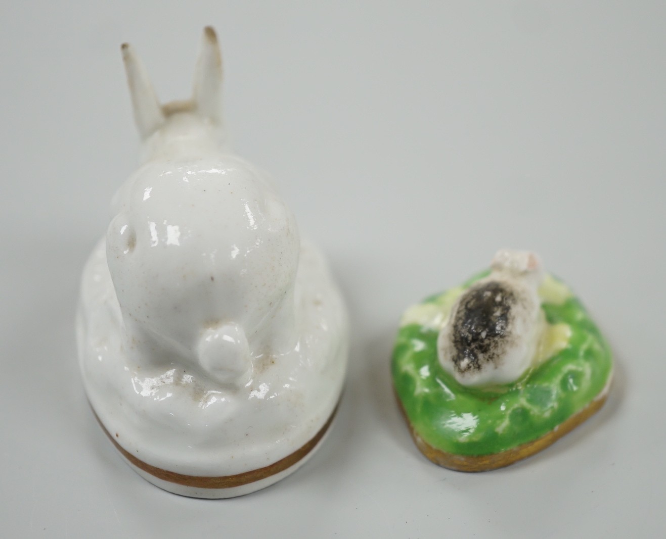 Two toy Staffordshire models of a recumbent rabbit and a bunny, both on oval bases, c.1830-50, (2). Tallest 4cm, Provenance Dennis G.Rice collection